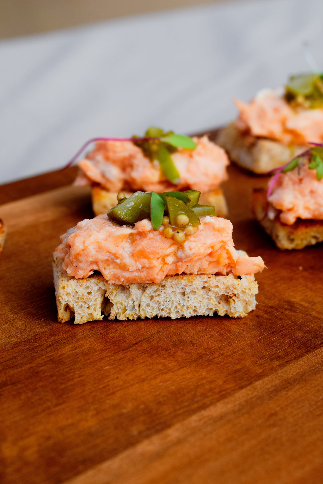 Canapés au saumon fumé dressés sur planche en bois