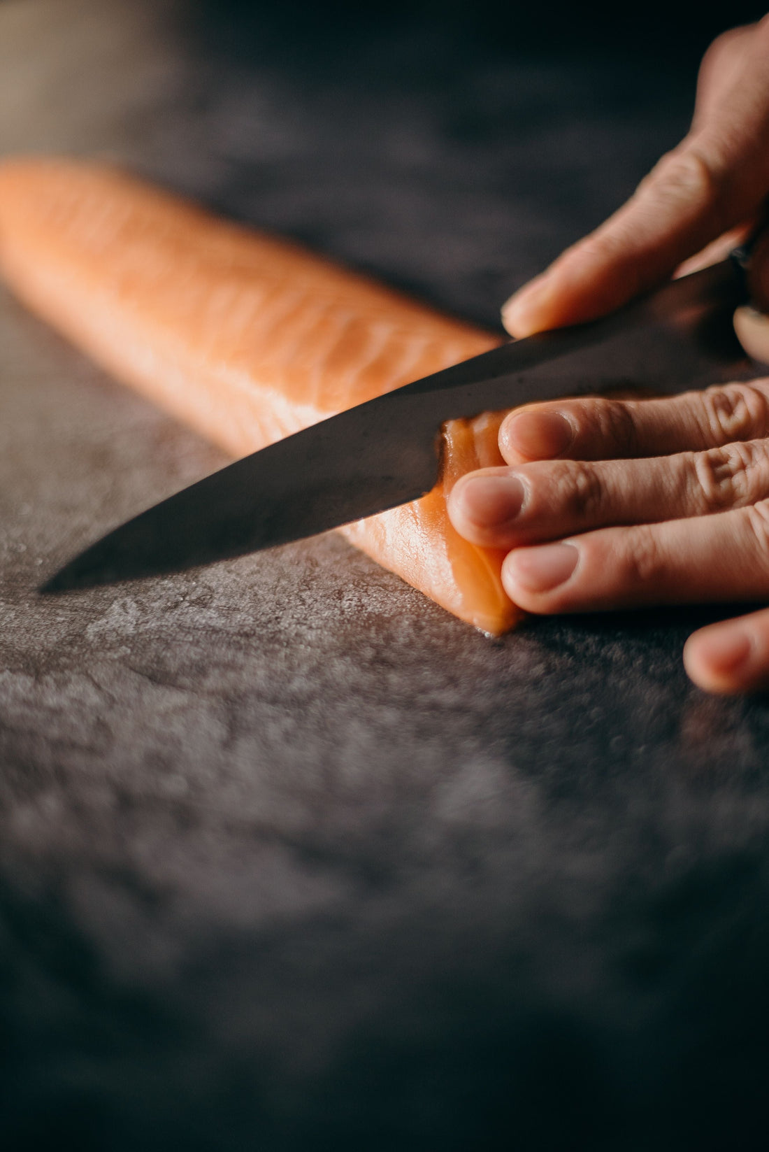 Découpe de tranches fines de saumon fumé au couteau